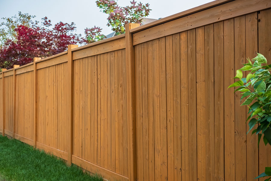 a wooden fence with grass and trees